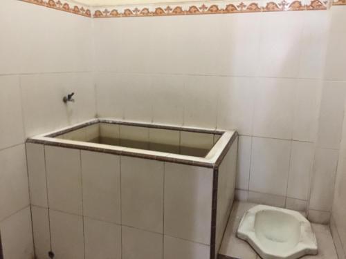 a bathroom with a urinal and a toilet at OYO Life 93525 Griya Wafira Trenggalek Syariah in Trenggalek