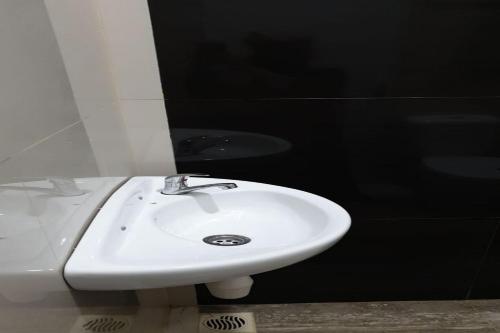 a bathroom with a white sink and a mirror at Hotel O Wisma Haji BunbunNearYani Heahlerr in Rantau