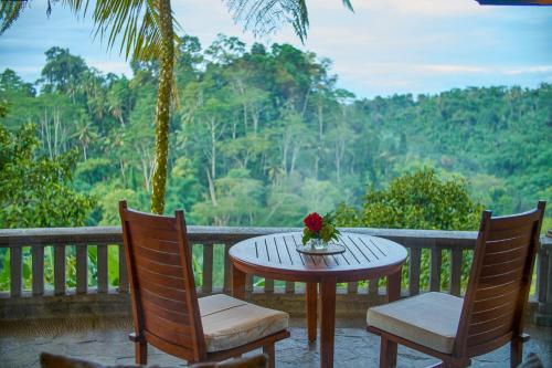a table with a vase of flowers on a porch at Bagus Jati Health & Wellbeing Retreat in Tegalalang