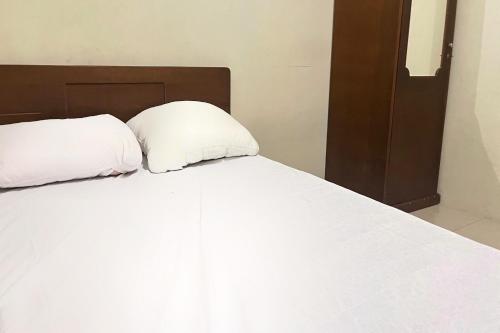 Кровать или кровати в номере Hotel O Penginapan Laras PaminggirNearPesona Alam Seafood Pink Mira
