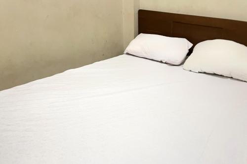 Кровать или кровати в номере Hotel O Penginapan Laras PaminggirNearPesona Alam Seafood Pink Mira