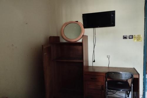 a desk with a mirror and a chair in a room at Hotel O Pondok Gusang Kuala Near Pelabuhan H Basran in Pagatan