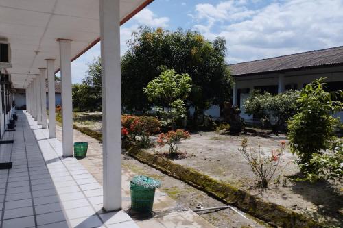 an outside view of a building with a garden at Hotel O Pondok Gusang Kuala Near Pelabuhan H Basran in Pagatan