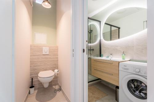une salle de bain avec toilettes et lavabo et une machine à laver dans l'établissement L'Icare par Dodo à Cassis, à Cassis