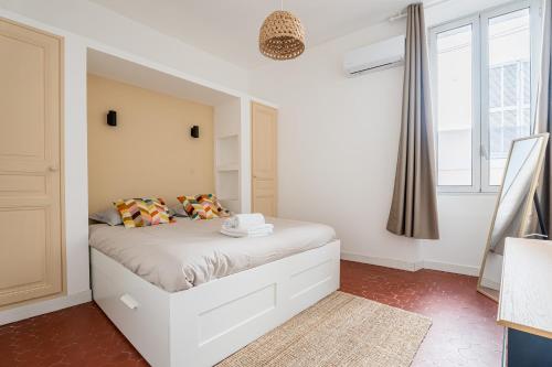 une chambre avec un lit blanc avec une fenêtre dans l'établissement L'Icare par Dodo à Cassis, à Cassis