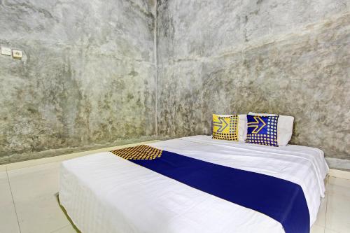 a small room with a bed with two pillows on it at Hotel O Agus Kostel SyariahNearWisata Agro Jollong in Gembong