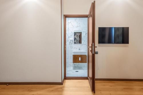 an open glass door with a television on a wall at Terrace Akhaltsikhe in Akhaltsikhe