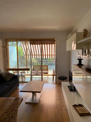 un salon avec un canapé et une table dans l'établissement Appartement lumineux et climatisé, face au parc privé et à 10 mins de la plage, à Cagnes-sur-Mer