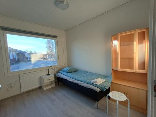 a small bedroom with a bed and a window at Koivukuja in Kokkola