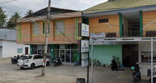 a group of buildings with cars parked in front of them at OYO 93411 Syariah Hotel Tomborang in Karema