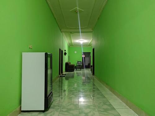 an empty hallway with green walls and a green wall at OYO 93411 Syariah Hotel Tomborang in Karema