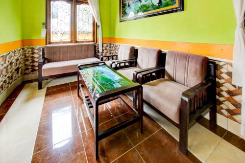 a waiting room with couches and a glass table at OYO Life 93260 Bale Kosan in Tanjung