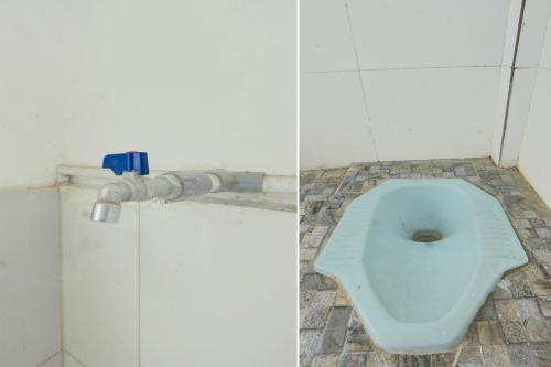 a bathroom with a blue toilet in a stall at OYO Life 93260 Bale Kosan in Tanjung