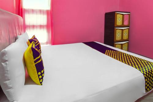 a bedroom with a bed with a yellow and purple tie at OYO Life 93405 Montong Are Residence in Tjakranegara