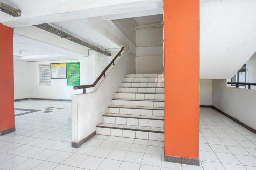 a staircase in a building with an orange pole at OYO Life 93405 Montong Are Residence in Tjakranegara