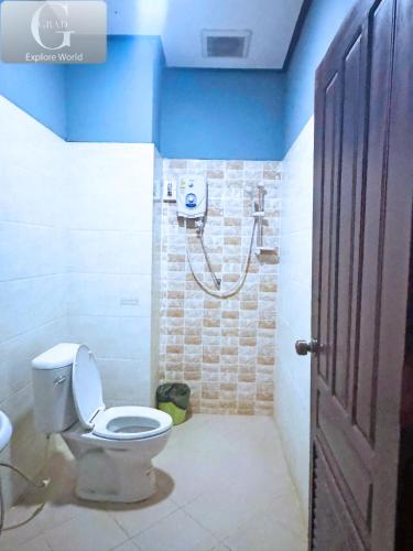 a bathroom with a toilet and a shower with blue walls at Vang Vieng Misokxay Hotel in Vang Vieng