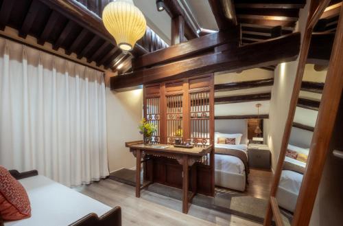 a bedroom with a bed and a desk in a room at Beijing Le Zai Nan Luo Gu Xiang Wang Fu Jing Forbidden City Courtyard Hotel&Free laundry service&Free coffee &Paid Dumpling experience service in Beijing