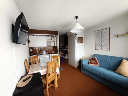 un salon avec un canapé bleu et une table dans l'établissement Résidence Chalmettes - Studio 2/4 personnes - Skis aux pieds MAE-9074, à Montgenèvre