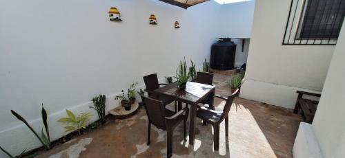 a dining room with a table and chairs and plants at Casa en Puesta del Sol/Excelente Ubicación/2 Hab/Wifi/Netflix/Super comoda in Mérida