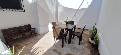 a dining room with a table and chairs and a bench at Casa en Puesta del Sol/Excelente Ubicación/2 Hab/Wifi/Netflix/Super comoda in Mérida