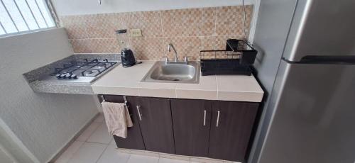 a small kitchen with a sink and a stove at Casa en Puesta del Sol/Excelente Ubicación/2 Hab/Wifi/Netflix/Super comoda in Mérida