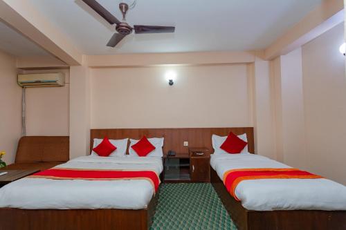 a hotel room with two beds with red pillows at OYO 801 Hotel View Global in Kathmandu