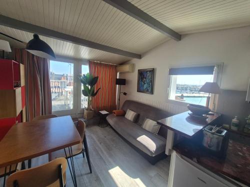 - un salon avec un canapé et une table à manger dans l'établissement Morena - Superbe Duplex, Terrasse avec vue mer, Wifi, Climatisation, à La Rochelle