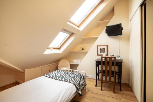 a attic bedroom with a bed and a desk at OYO Lina Guest House in Oxford