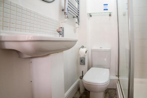 a small bathroom with a toilet and a sink at OYO Lina Guest House in Oxford
