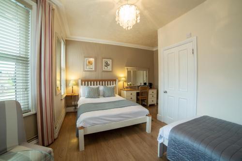 a bedroom with two beds and a chandelier at OYO Lina Guest House in Oxford