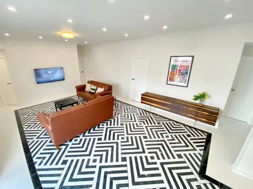 a living room with a couch and a rug at 6mins to airport Large Family House in Auckland