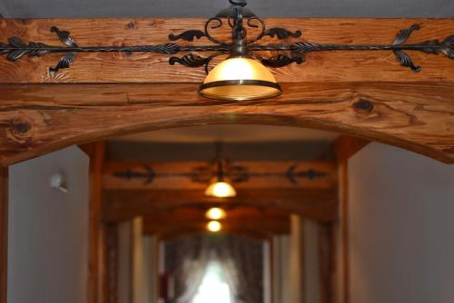 una luz colgada del techo de madera con un espejo en Granarollo Penzión Pizzeria, en Mlyňany