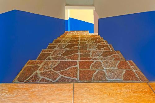 a room with a stone wall and blue walls at Hotel O Wisma Dua Putra Syariah in Majalengka