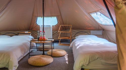 a room with four beds in a tent at Xiang Yue Lake International Resort in Deqing