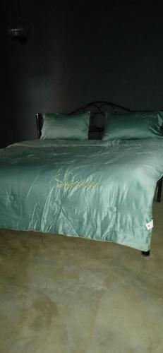 a green bed with two pillows on top of it at BP Room 2 budget in Ko Mak