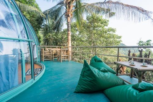 a room with a couch and a table on a balcony at Leela Garden Resort Bubble house in Ban Nok
