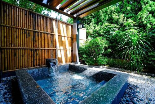 a hot tub in the middle of a garden at Lynn Times Thanh Thuỷ Hotel in Xuân Vi