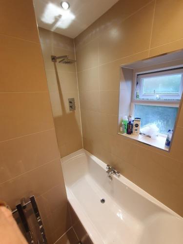 a bathroom with a bath tub and a window at Duck Cottage beautiful views countryside village in Delph