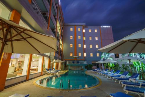 a hotel swimming pool with lounge chairs and umbrellas at Chabana Kamala Hotel in Kamala Beach