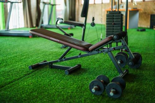 a gym with a bench and weights on the grass at Chabana Kamala Hotel in Kamala Beach