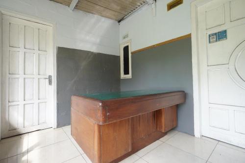 OYO 93628 Scorpion Guest House & Beach في تولونغاغونغْ: غرفة بها كونتر خشبي وباب