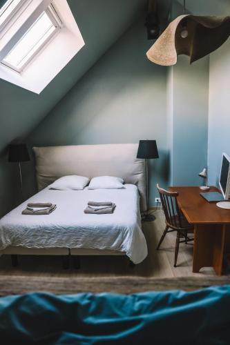 une chambre avec un lit et un bureau avec un ordinateur portable dans l'établissement Ikigai Fontainebleau - Cottage, à Villiers-sous-Grez