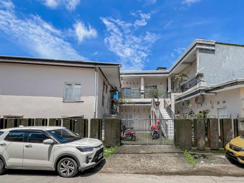 a white car parked in front of a house at Hotel O Kost Naura in Sungguminasa
