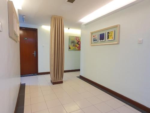 an empty hallway with a door and a curtain at Capital O 90939 Sandakan Central Hotel in Sandakan