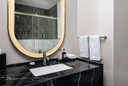 a bathroom with a sink and a mirror at Origin Austin, a Wyndham Hotel in Austin