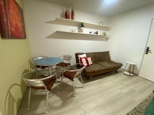 a living room with a table and a couch at Studio Beira Mar Piscina Cobertura Localização perfeita Jatiúca in Maceió