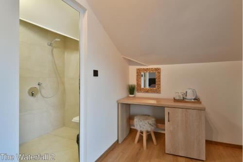 uma casa de banho com um chuveiro e um toucador com um lavatório. em The Waterfall Free Parking em Balchik