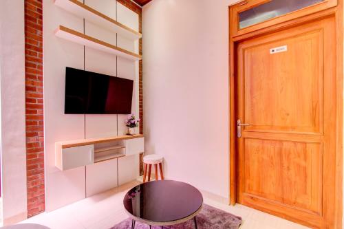 a room with a door and a tv and a stool at Capital O 93718 Homestay 3 Bidadari in Yogyakarta