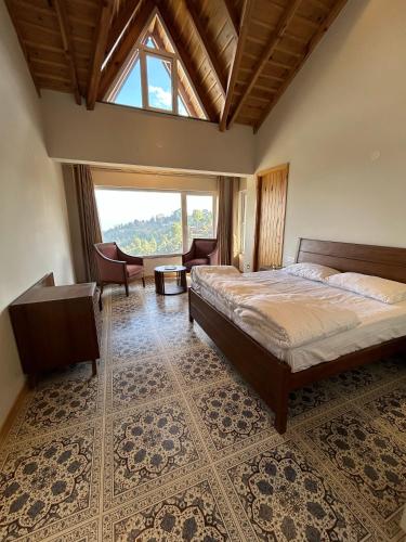 a bedroom with a bed and a large window at VAAS Cottage in Mukteshwar