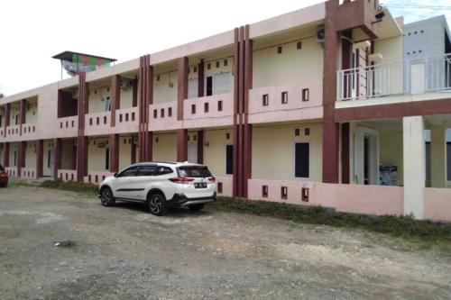 a white car parked in front of a building at Hotel O Pondok Zamzam Near Taman Arung Palakka, Bone in Pakato